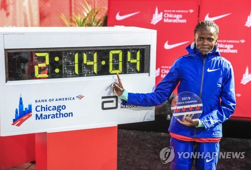 브리지드 코스게이가 13일(현지시간) 미국 시카고에서 열린 2019 시카고 마라톤에서 2시간14분04초의 세계기록을 세우며 결승 테이프를 끊고 있다. EPA=연합뉴스